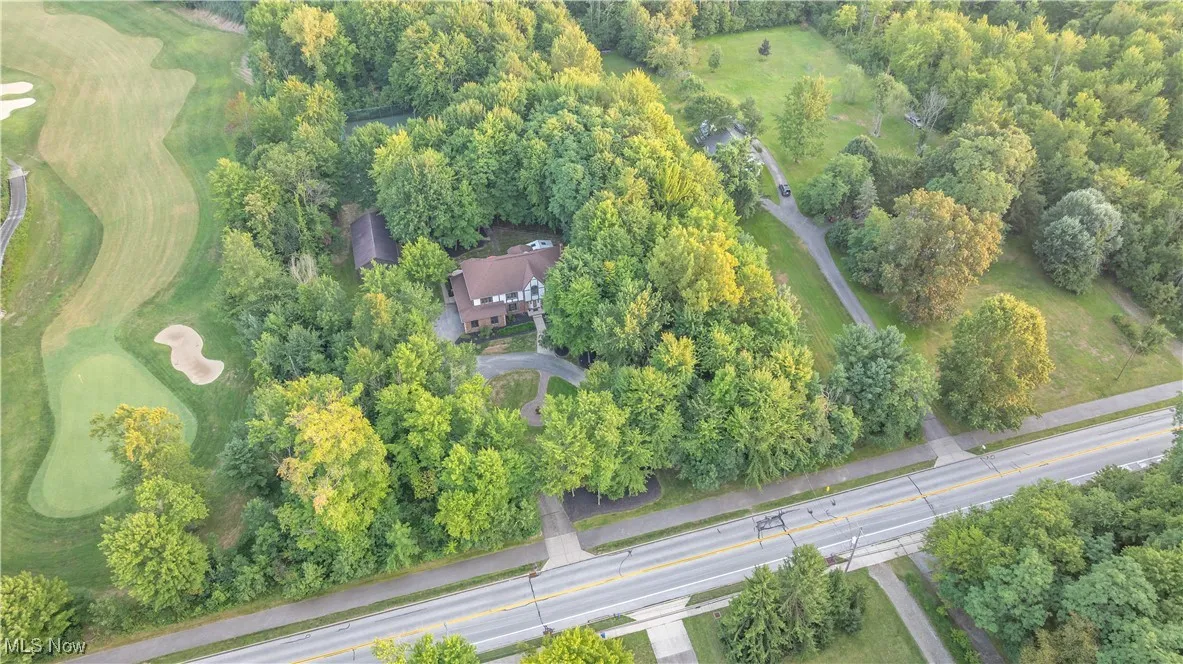 Aerial view of property and surrounding area featuring a golf course