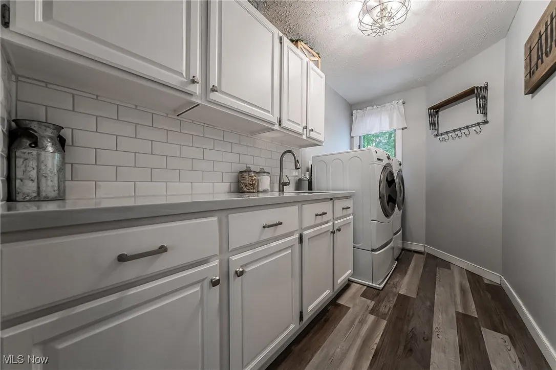 A beautifully updated 2nd floor Laundry is a featuring washing machine and clothes dryer, lots of cabinet space, and LTV flooring.