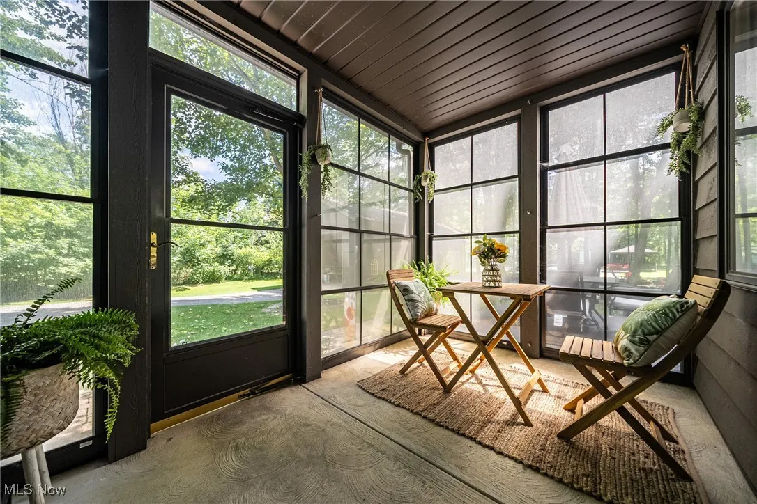 Screened side porch off kitchen featuring plenty of natural light