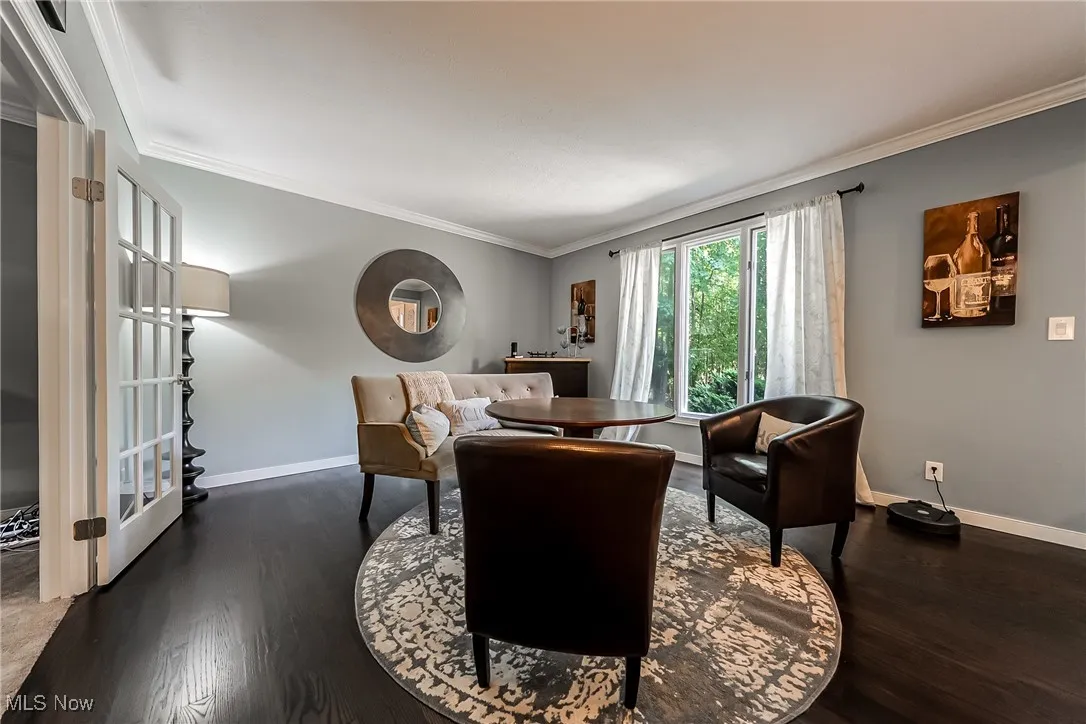 Living area with ornamental molding and wood finished floors