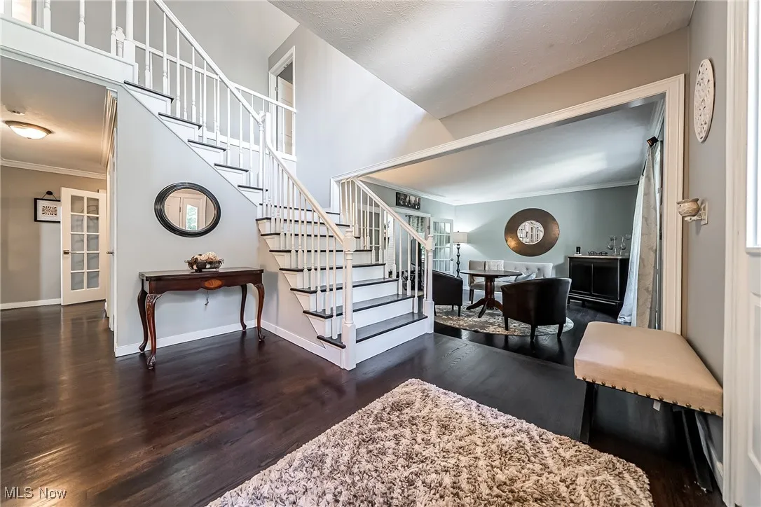Entry with crown molding and wood finished floors
