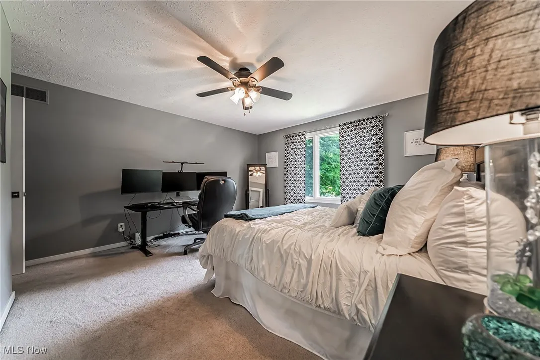 Bedroom #2 with carpet flooring, and ceiling fan has a view to the front circle driveway  ceiling fan