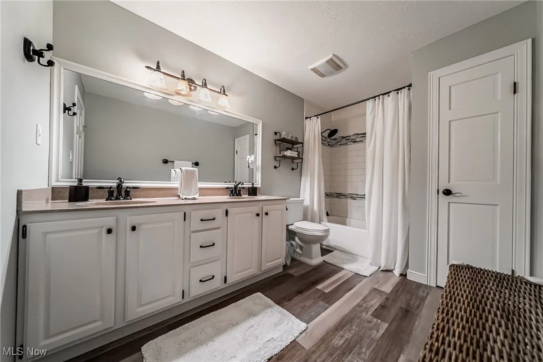 Updated 2nd floor Hall Bathroom featuring LTV floors, double vanity, shower / bathtub combination with updated surround, and a linen closet.