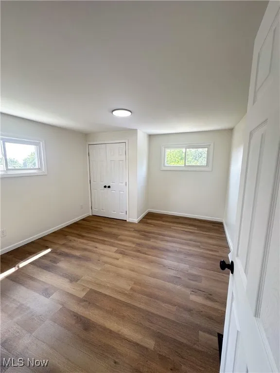Empty room featuring wood finished floors and baseboards