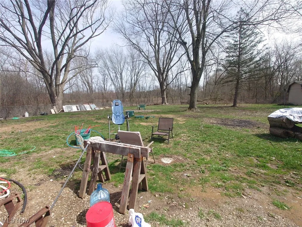 View of grassy yard with a wooded view