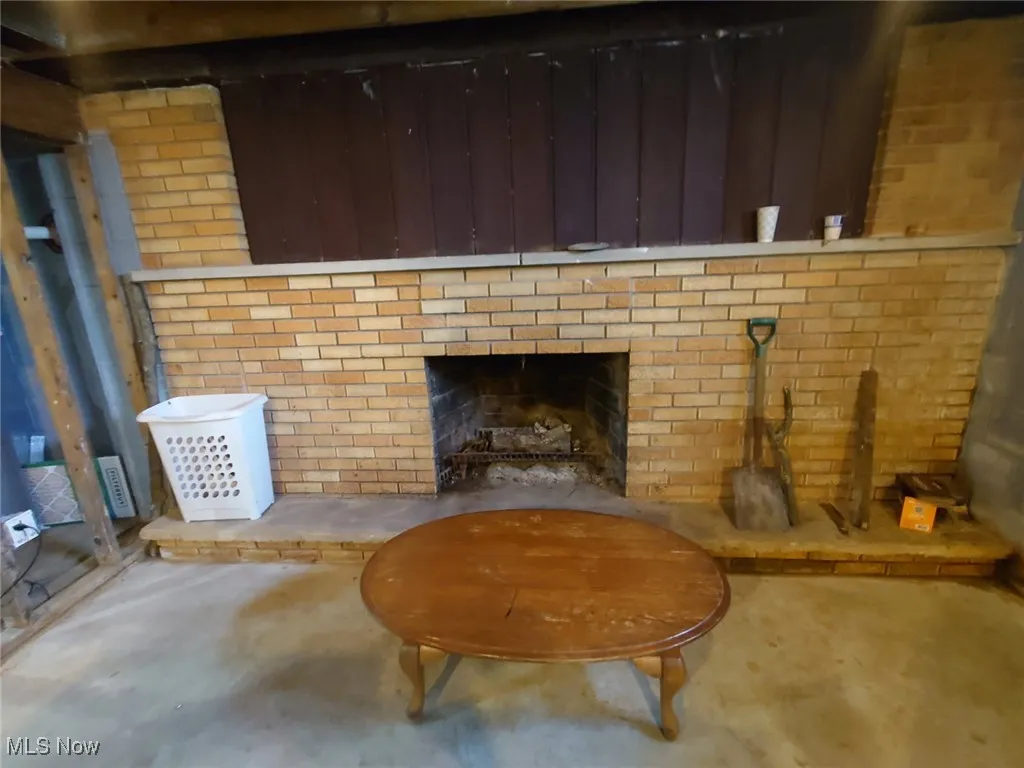 Detailed view of a brick fireplace and unfinished concrete floors