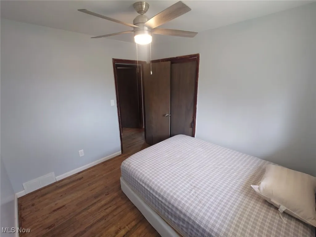 Bedroom featuring dark wood-type flooring and ceiling fan