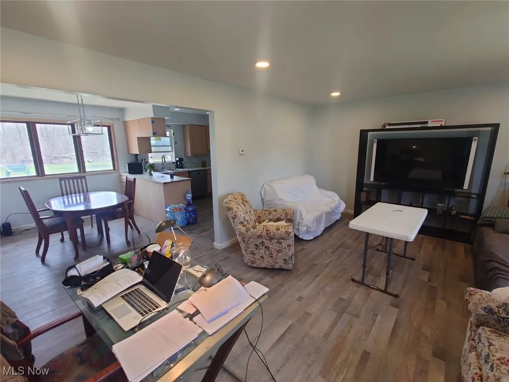 Living room with wood finished floors, recessed lighting, and a chandelier