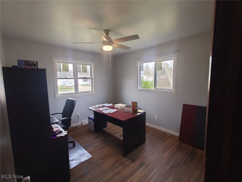 Office area featuring dark wood finished floors, healthy amount of natural light, and ceiling fan