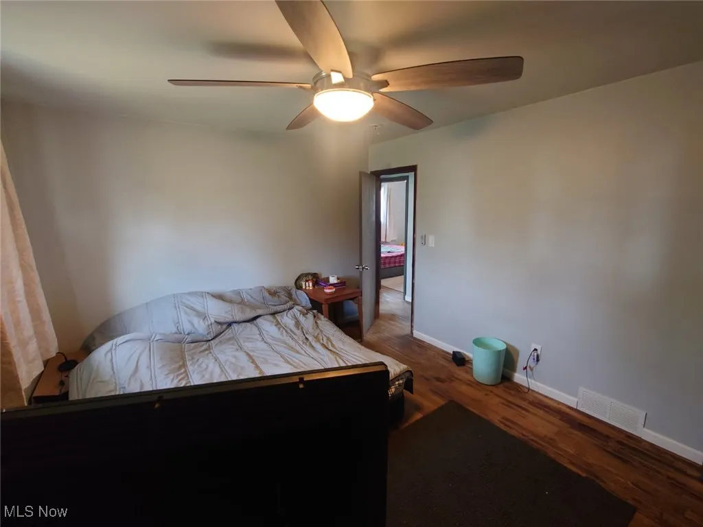 Bedroom featuring dark wood-style floors and a ceiling fan