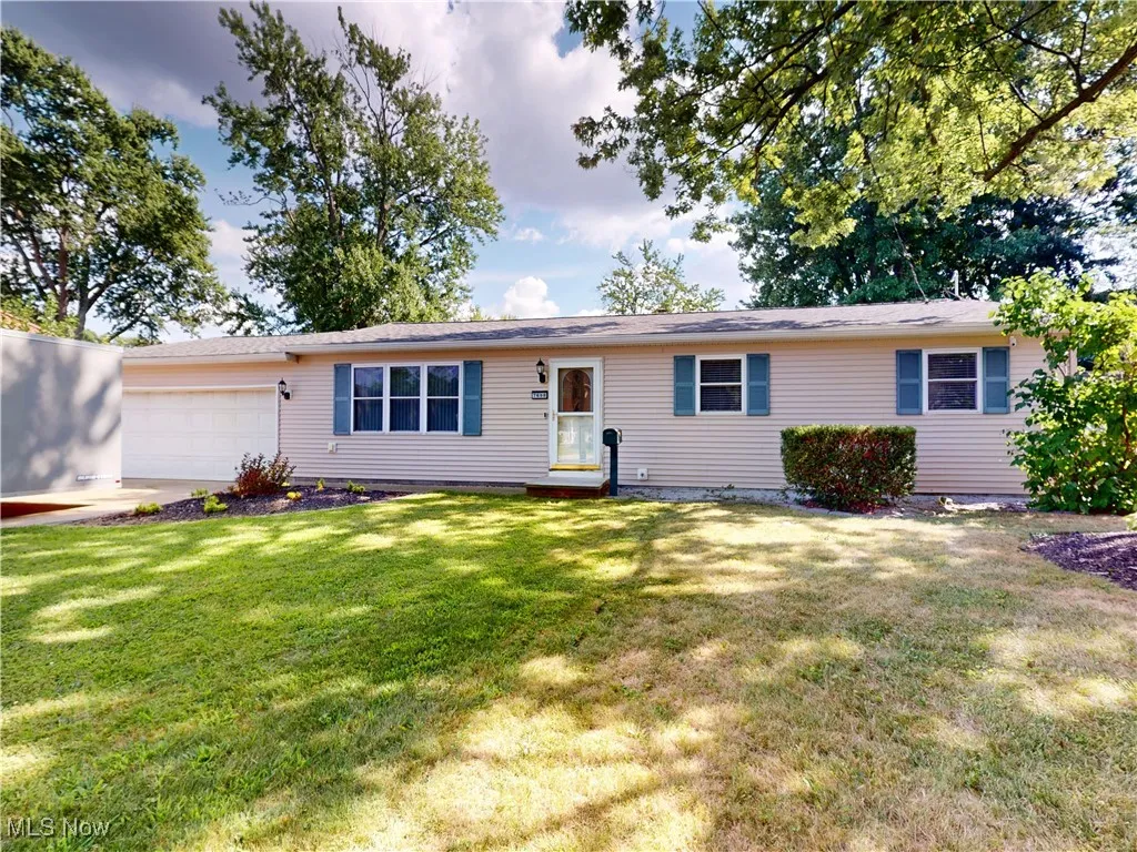 Ranch-style home featuring a garage and a front lawn