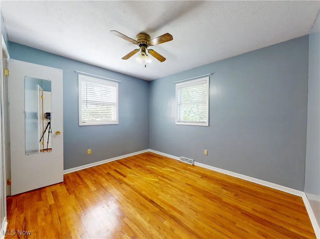 Unfurnished room featuring light wood-style flooring, a textured ceiling, and ceiling fan