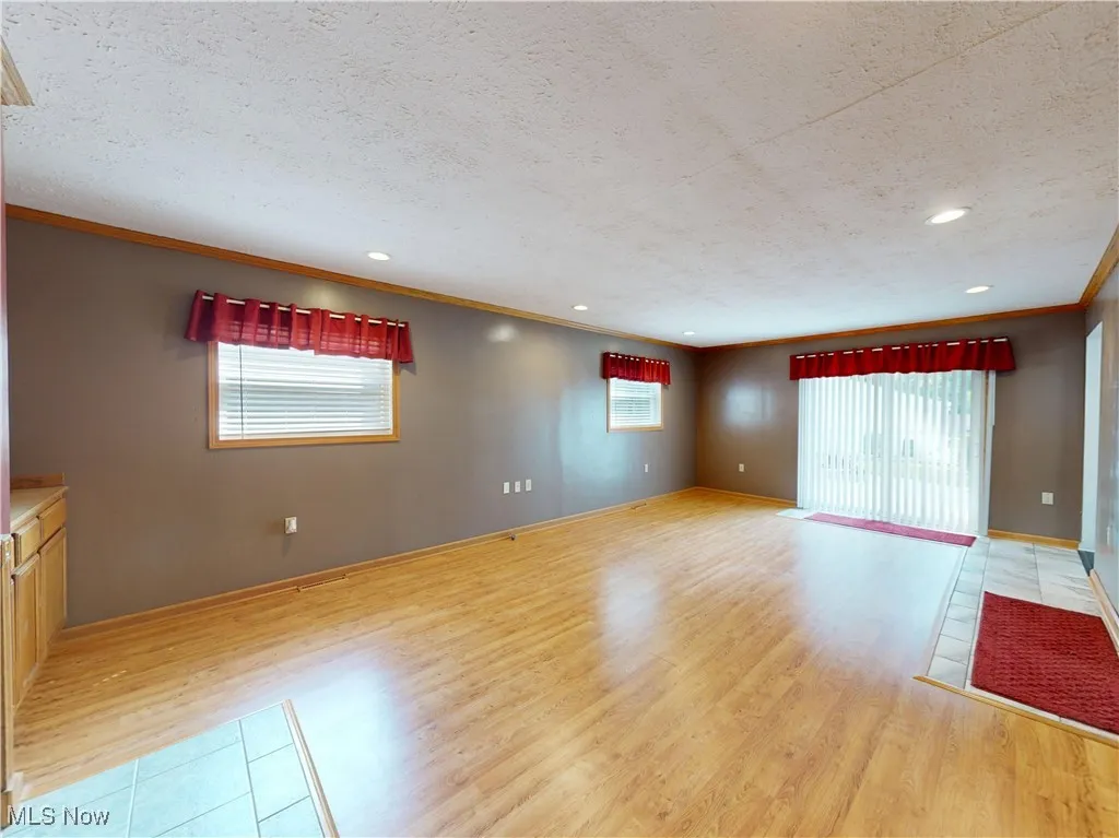 Spare room featuring crown molding, wood finished floors, recessed lighting, and a textured ceiling