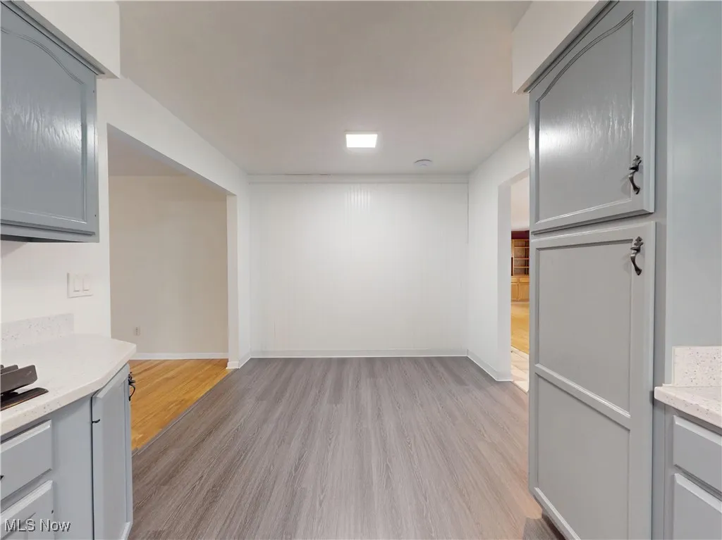 Unfurnished dining area with light wood-style floors and baseboards