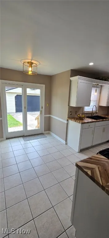 Kitchen featuring white cabinets and light tile patterned flooring