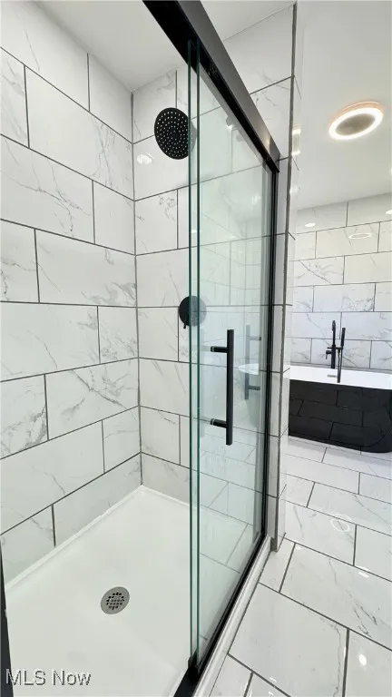 Bathroom with a shower stall and a garden tub