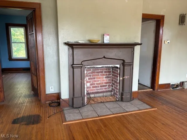 Detailed view of wood finished floors and a fireplace with flush hearth