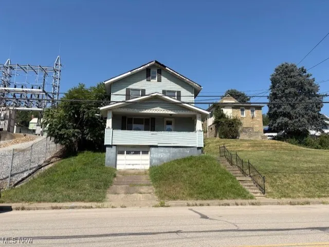 View of front of house featuring covered porch and a front lawn