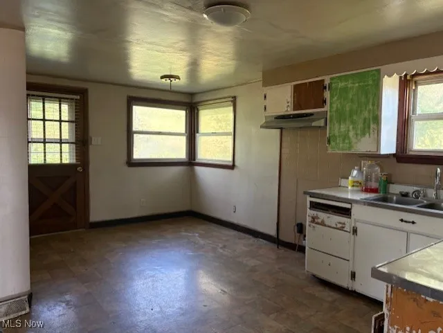 Kitchen with plenty of natural light, dark floors, and light countertops