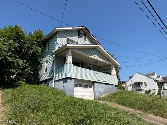 View of home's exterior with a garage and a balcony