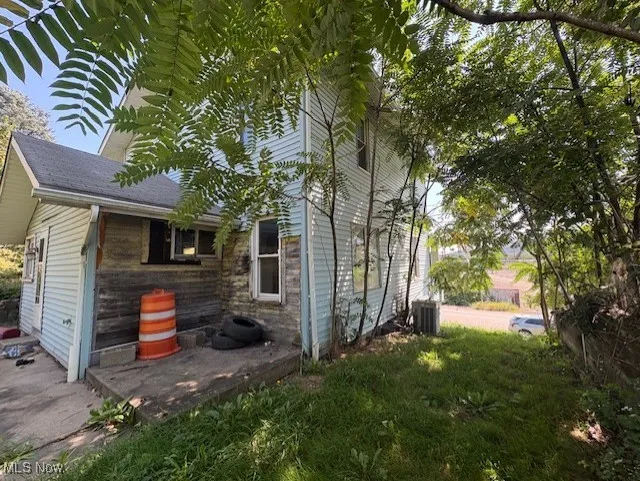 View of side of home with a central AC unit
