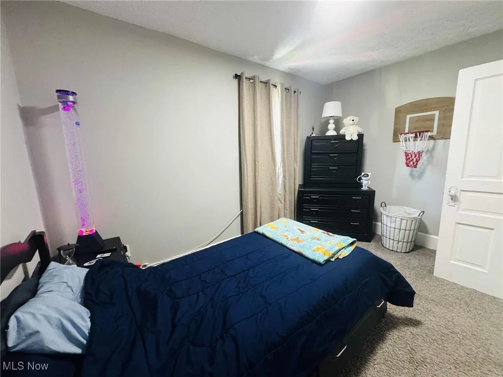 Bedroom featuring carpet flooring and a textured ceiling