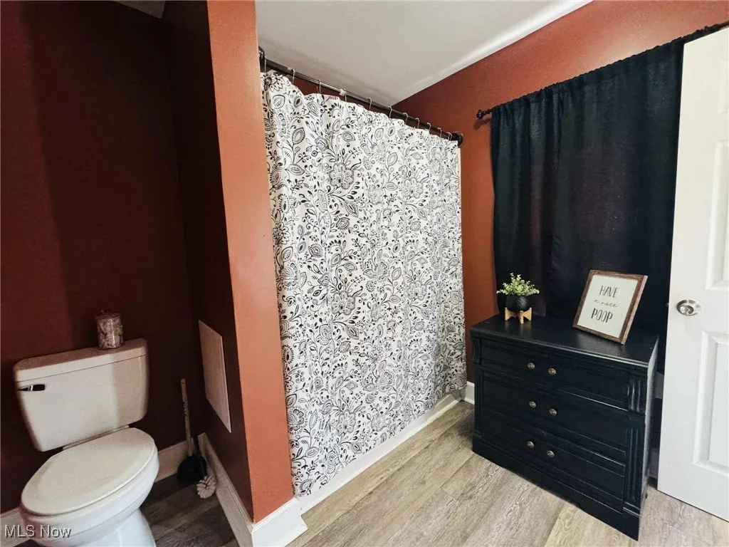 Bathroom with light wood-type flooring and a shower stall