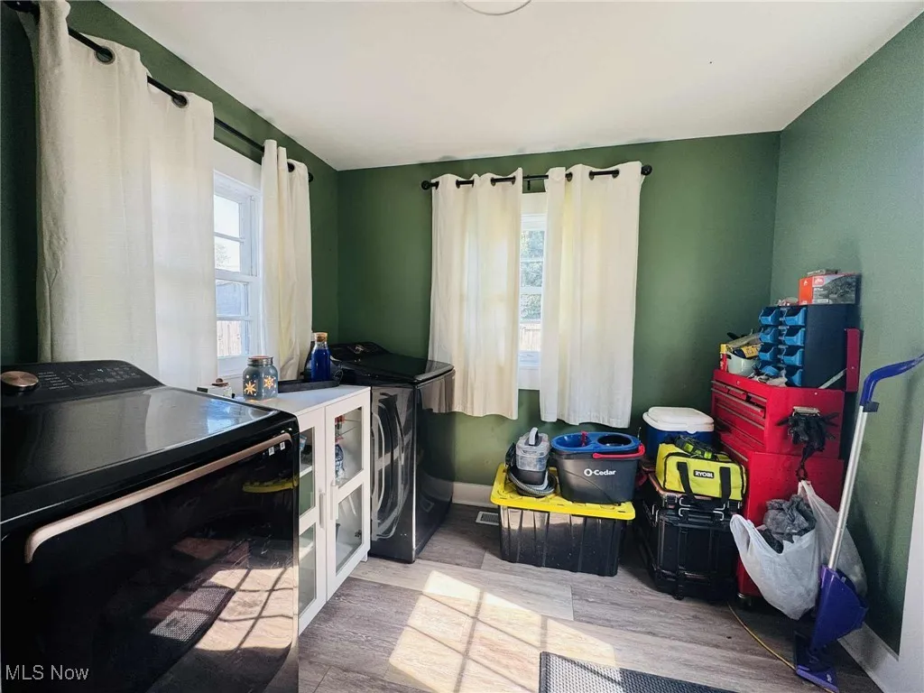Laundry area with washing machine and clothes dryer and wood finished floors