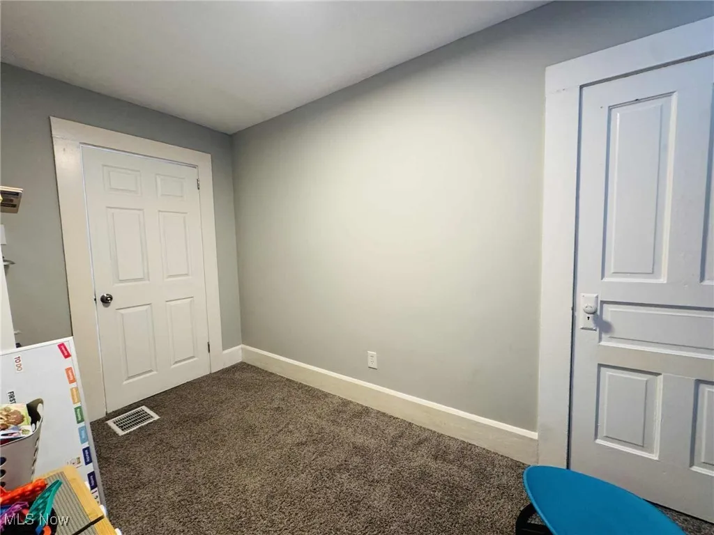 Unfurnished bedroom with carpet flooring and baseboards