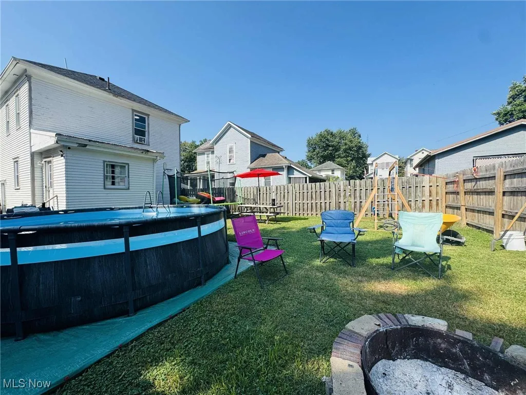 Fenced backyard with a fire pit and a residential view