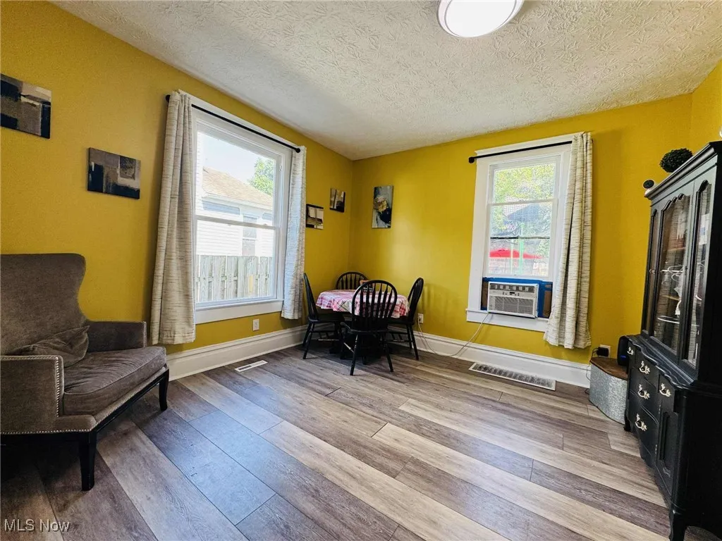Living area featuring healthy amount of natural light, light wood-style floors, and a textured ceiling