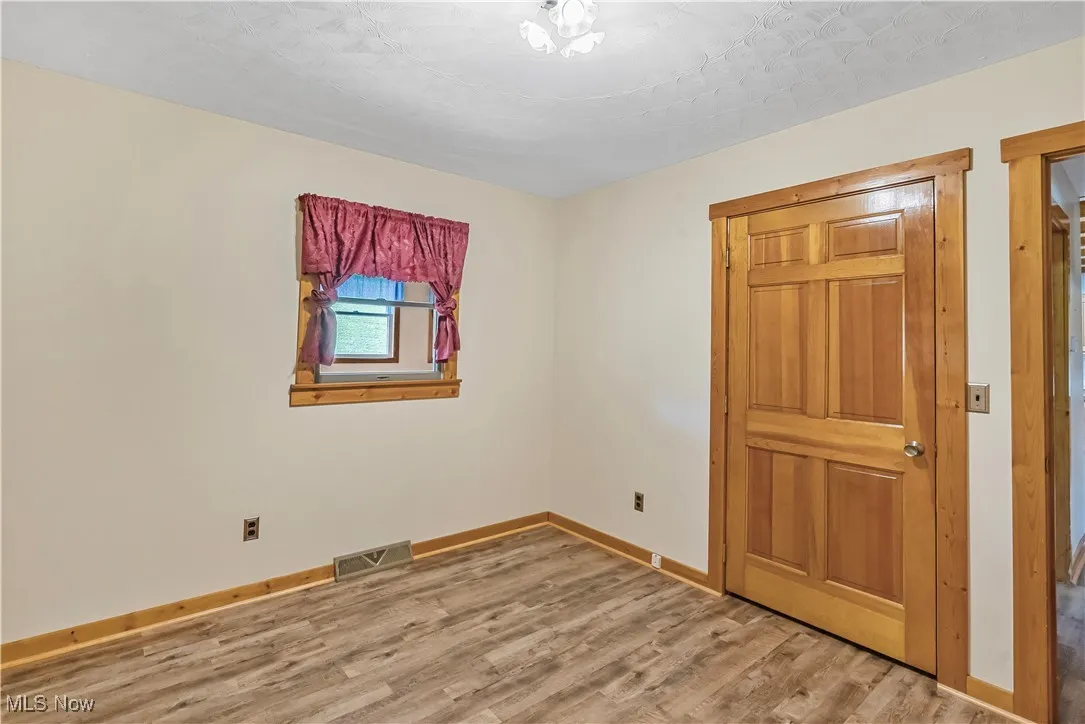 Unfurnished bedroom with light wood-style floors and baseboards
