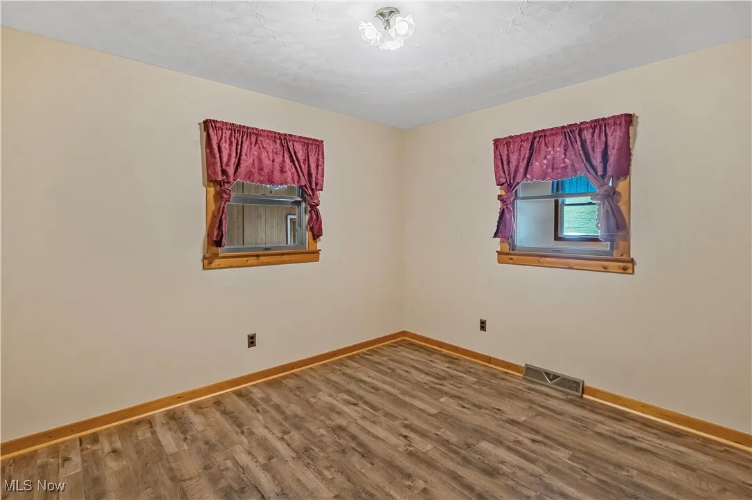Empty room with baseboards and wood finished floors