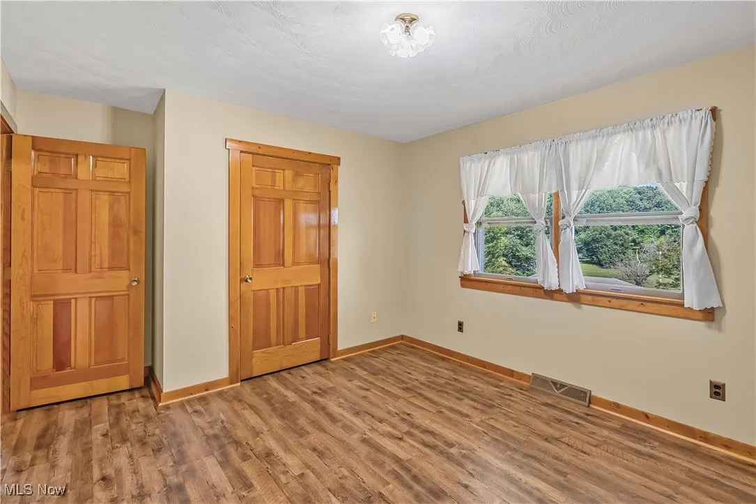 Unfurnished bedroom featuring baseboards and wood finished floors