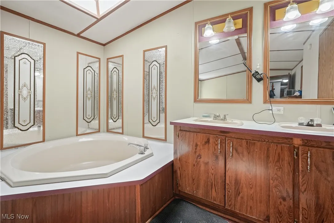 Full bathroom featuring a garden tub and lofted ceiling