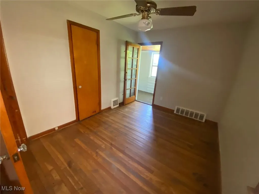 Spare room with wood finished floors and ceiling fan