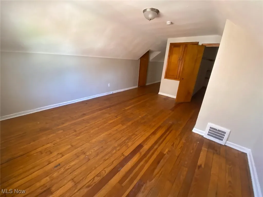 Bonus room featuring vaulted ceiling and dark wood finished floors
