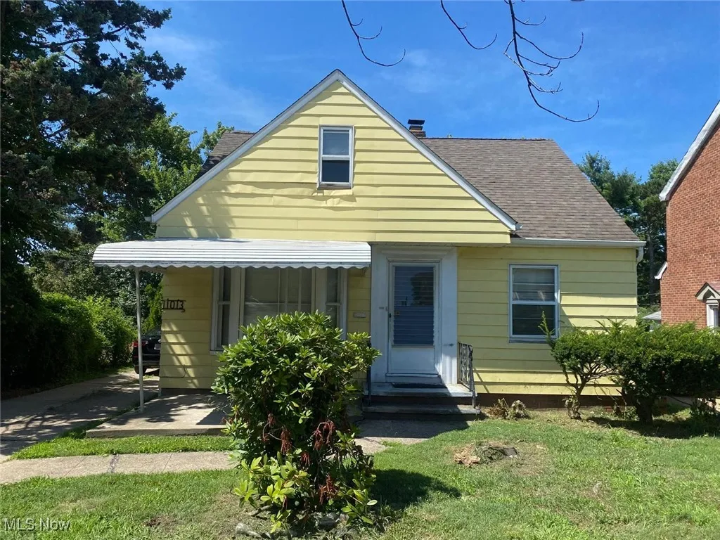 View of front of house featuring roof with shingles and a front lawn