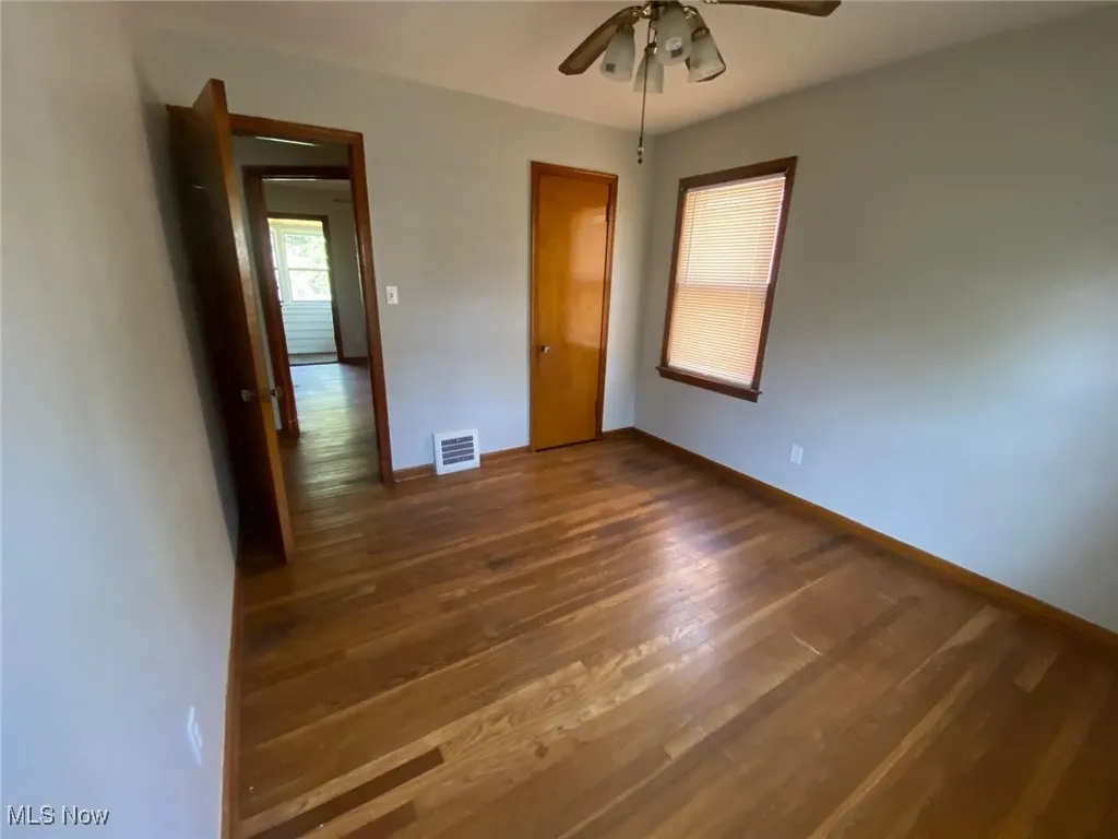 Unfurnished bedroom with wood finished floors and a ceiling fan