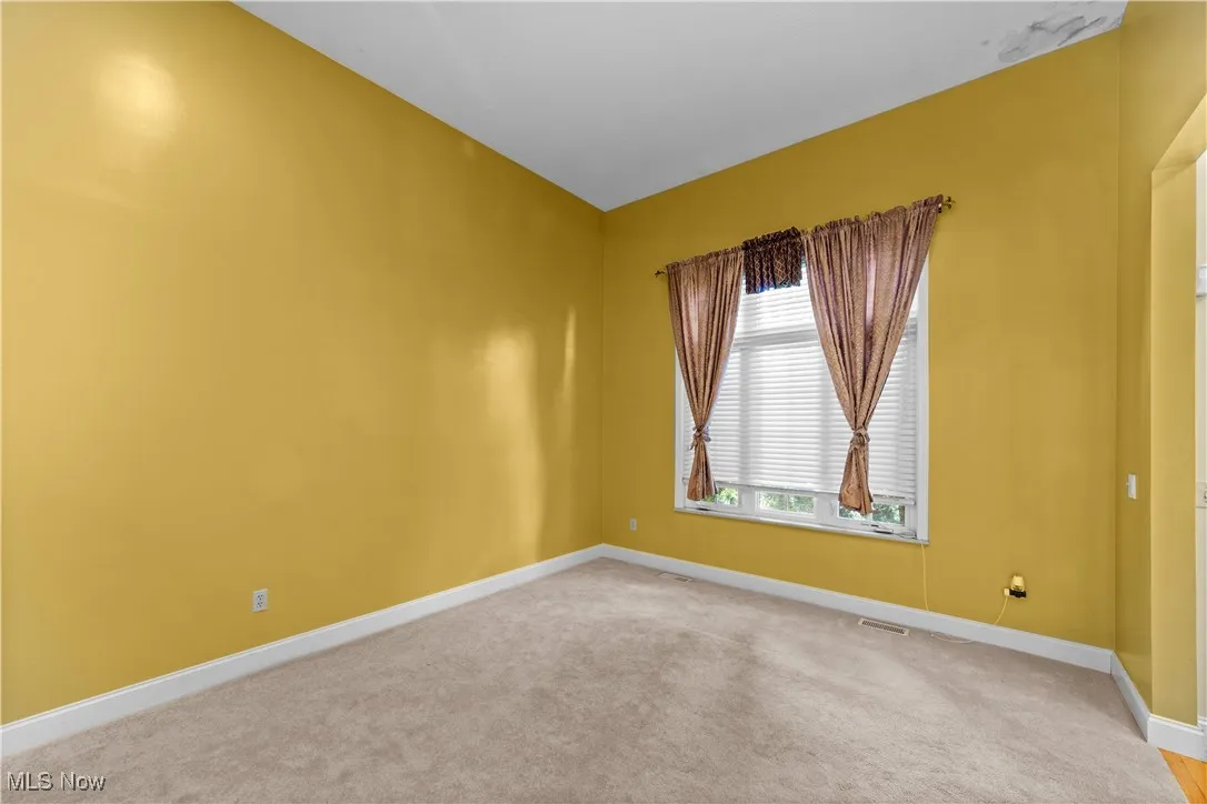 Empty room featuring carpet flooring and baseboards