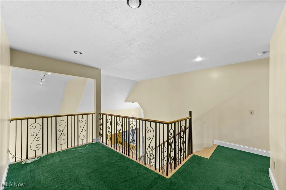 Hall with carpet, recessed lighting, and a textured ceiling