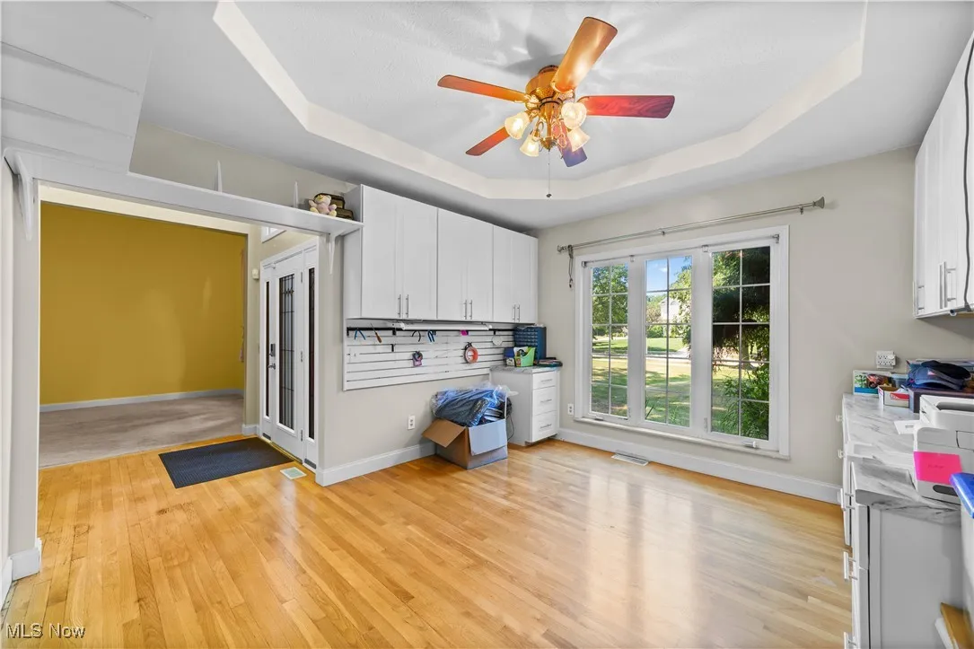 Dinning room featuring a tray ceiling, light wood-type flooring, and ceiling fan