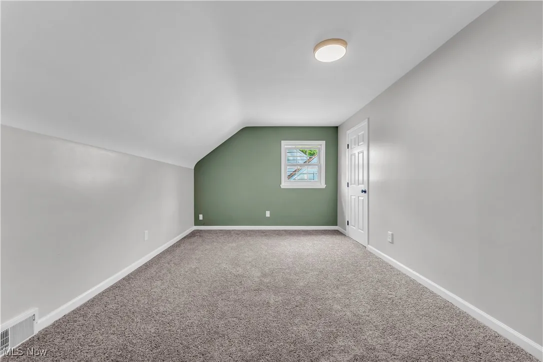 Bonus room featuring carpet flooring and vaulted ceiling