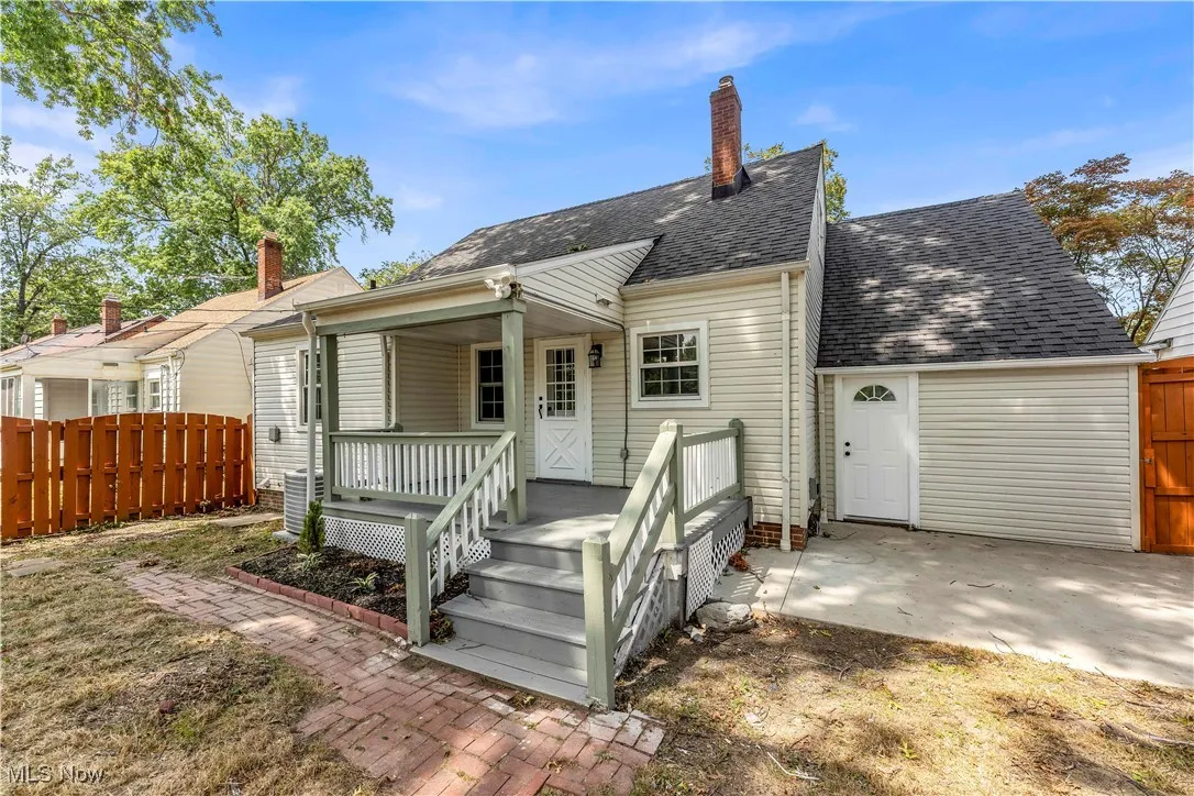 Back of property featuring roof with shingles, a chimney, and covered porch