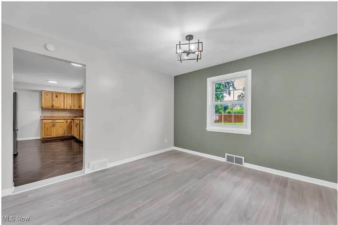 Unfurnished dining area featuring baseboards and dark wood-type flooring