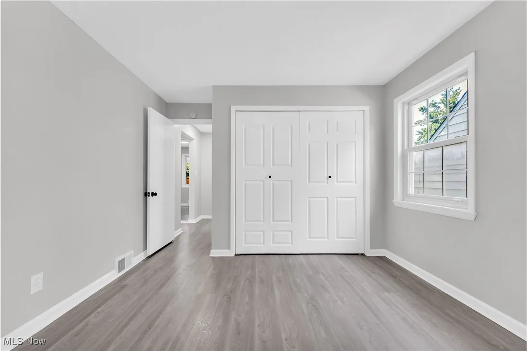 Unfurnished bedroom with wood finished floors and a closet