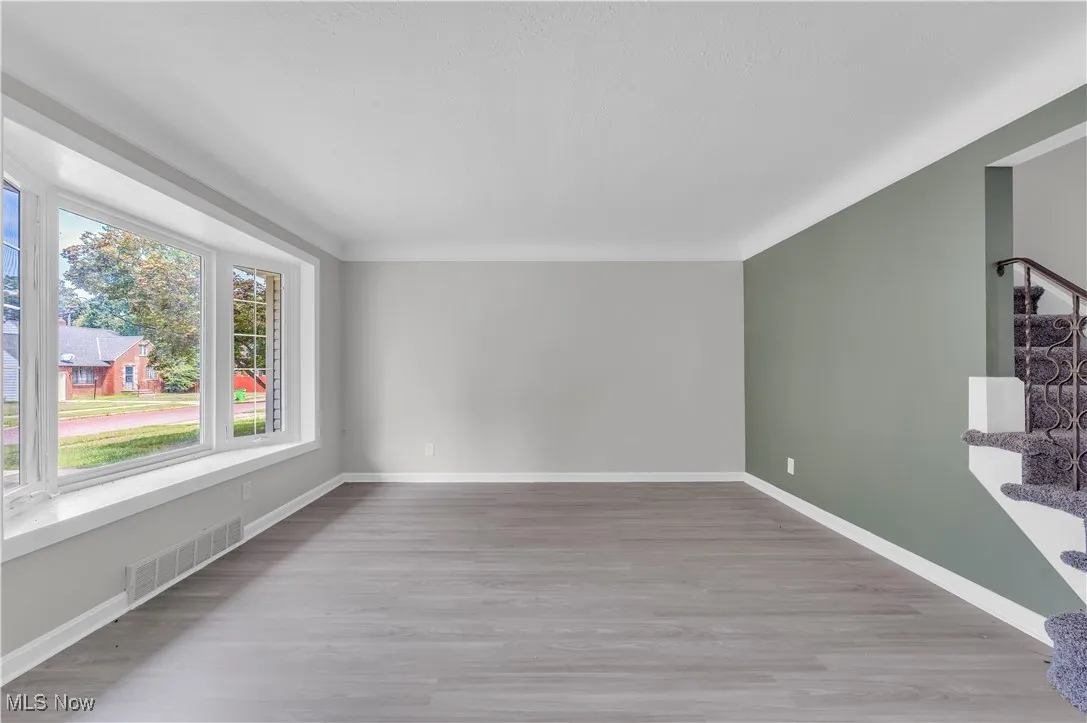Empty room featuring light wood-type flooring and stairs