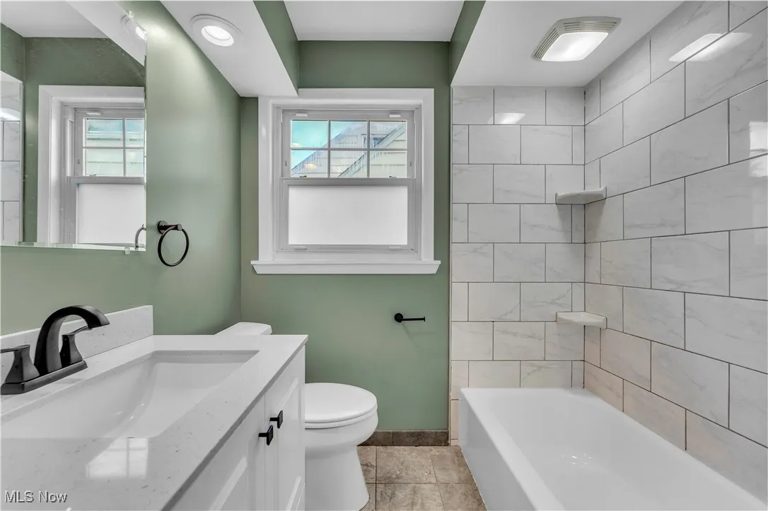 Full bathroom with vanity, shower / bath combination, and light tile patterned floors