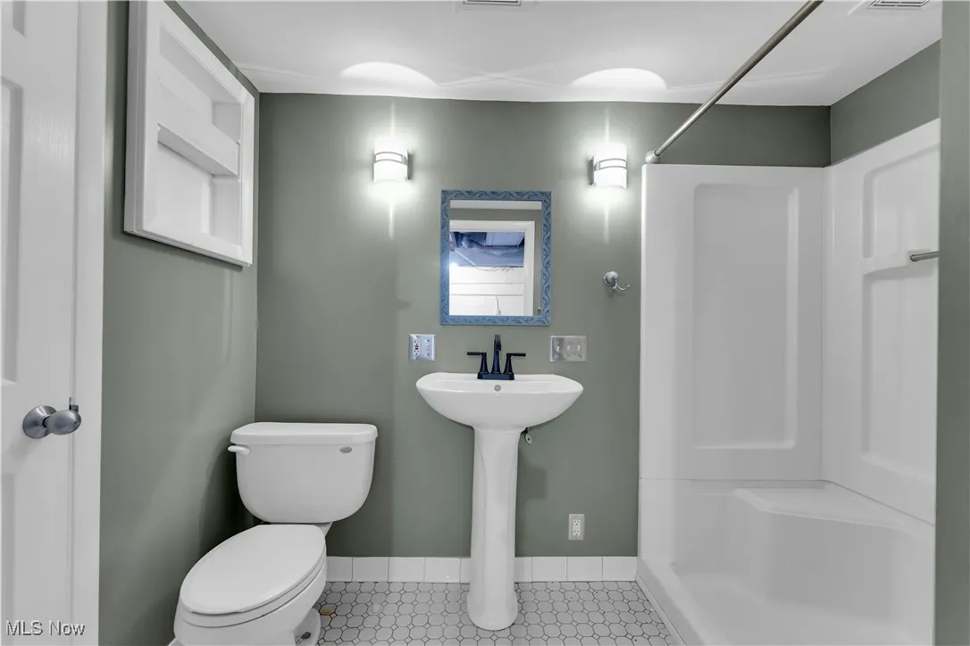 Full bath with a shower and tile patterned floors