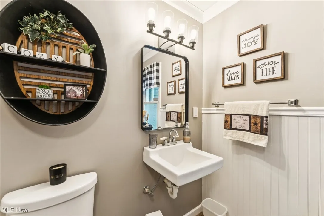 Bathroom featuring toilet and crown molding